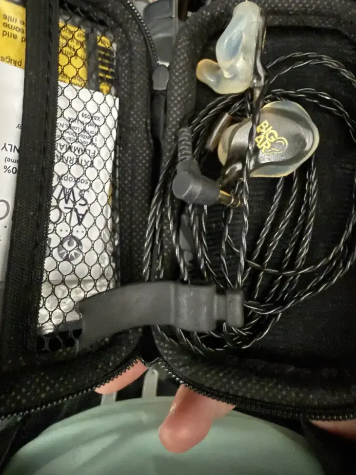 Big Ear soft-shell custom IEMs with the yellow faceplate, coiled in the carry case