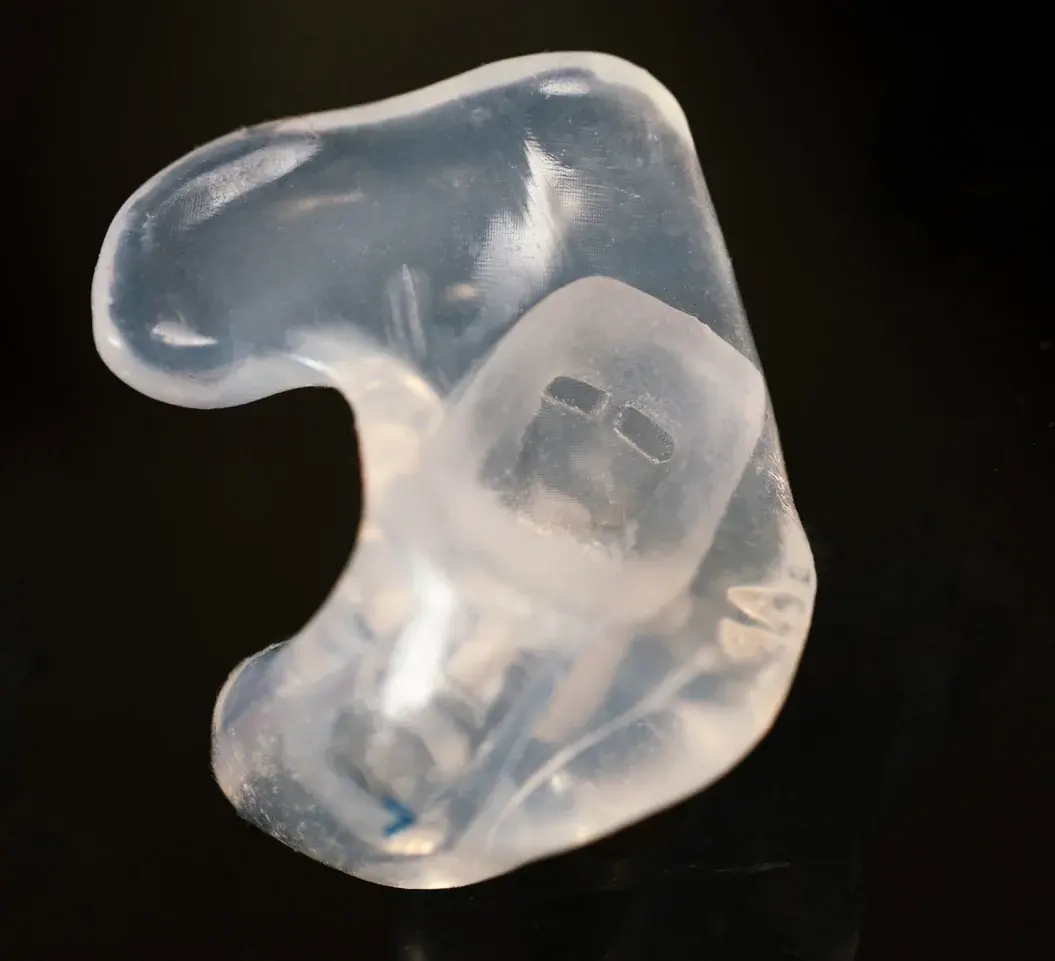 Custom Big Ear adapter for the Bose ProFlight, a clear molded pair on a dark surface