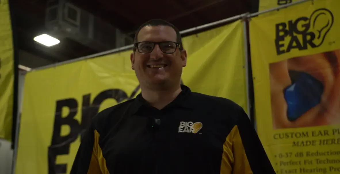 A smiling Big Ear team member at the booth