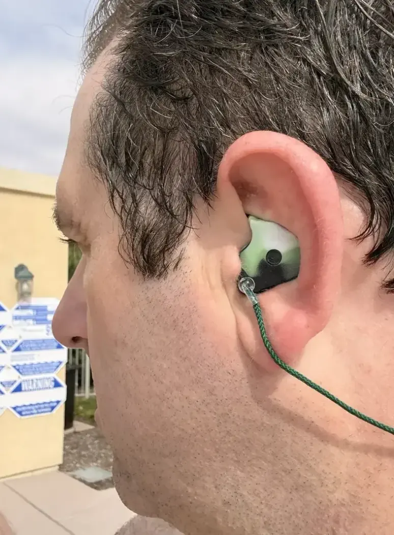A customer wearing a custom swimming earplug