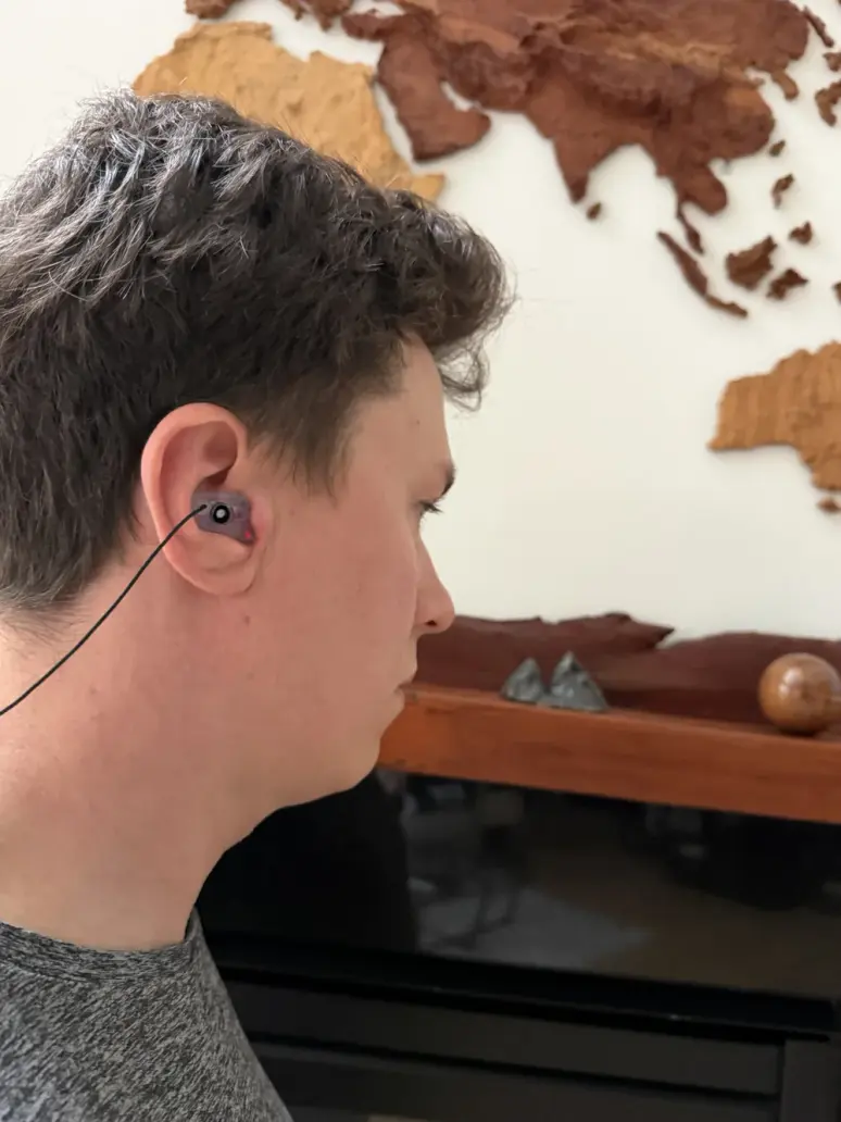 A customer wearing a purple custom The One filtered earplug