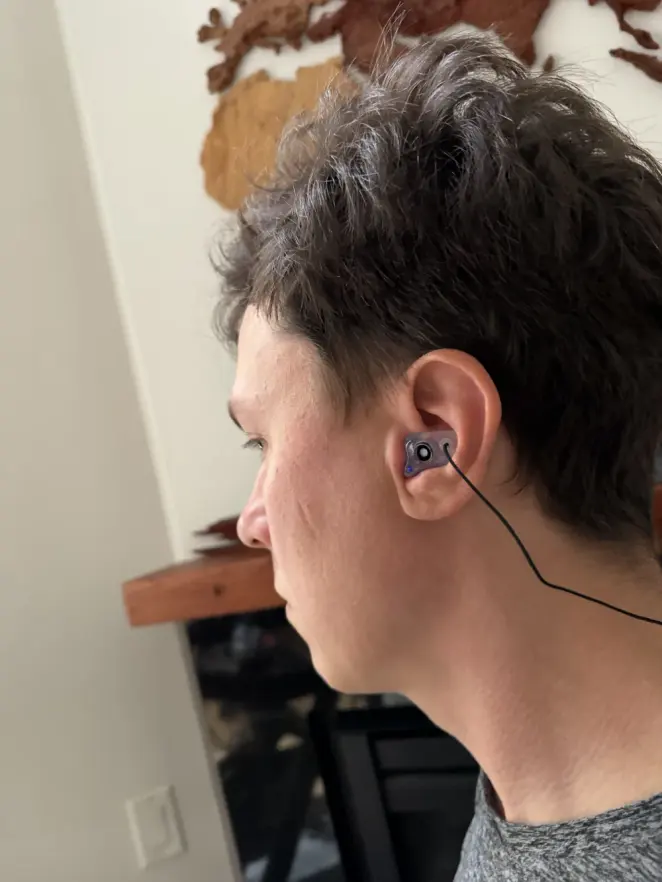 A customer wearing a purple custom The One filtered earplug, close view